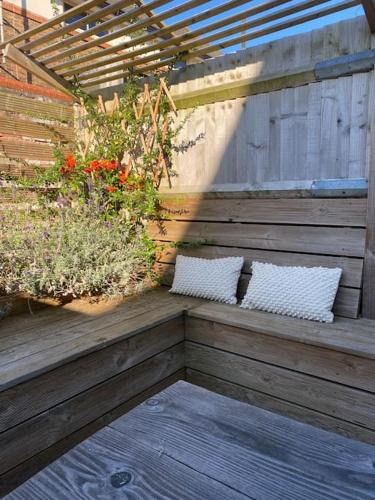 a wooden porch with two pillows and plants on it at Seaside Retreat in Broadwater