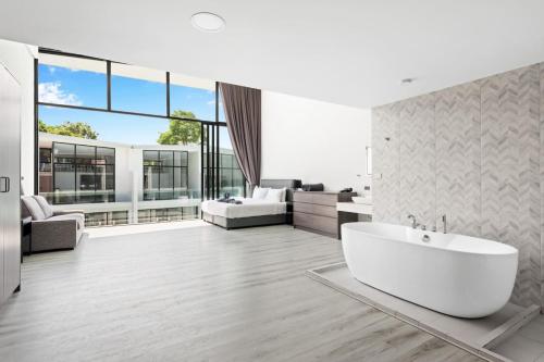 a white bathroom with a tub and a living room at Beach Walk Condo 3br in Replay residence in Bang Rak Beach