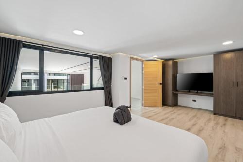 a bedroom with two white beds and a large window at Beach Walk Condo 3br in Replay residence in Bang Rak Beach