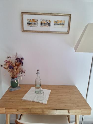 - une table avec une bouteille et un verre dans l'établissement Saint Jo Verte, chambre d' hôte Quartier Beaujoire Parc des expositions Parc Floral, à Nantes
