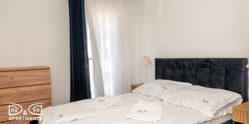 a bedroom with a bed with two towels on it at Pine Tree House 9 D&D Apartments in Międzywodzie