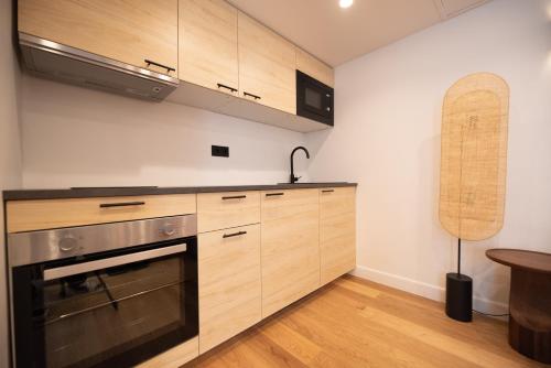 une cuisine avec des armoires en bois et un four à plaques de cuisson dans l'établissement CIA - Grands Boulevards, à Paris