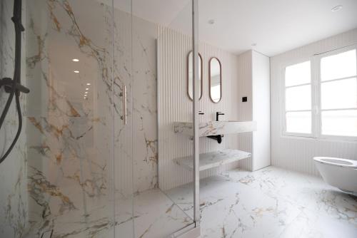 une salle de bain avec une douche en verre et des toilettes dans l'établissement CIA - Grands Boulevards, à Paris