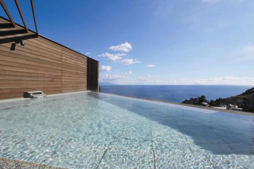 a swimming pool with a view of the ocean at Atagawa Prince Hotel in Higashiizu
