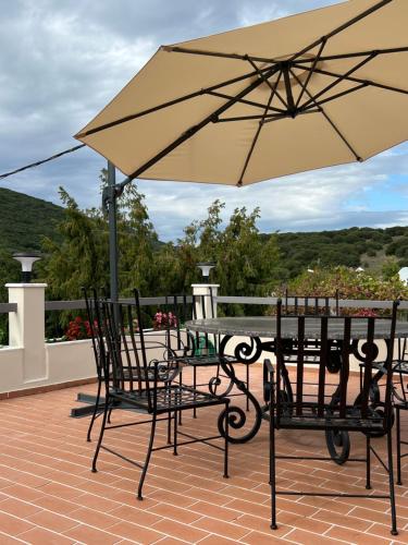 a table and chairs under an umbrella on a patio at Entire Apartment 140m2 near Syvota and Parga in Makrochóra