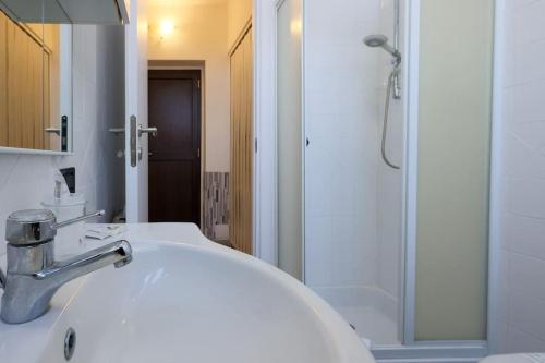 a bathroom with a white sink and a shower at Attico Frascati La Cattedrale, soggiorno esclusivo nel centro storico in Frascati