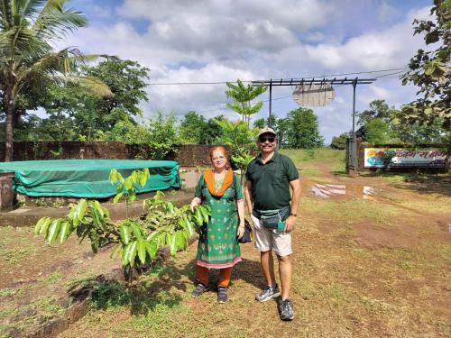a man and a woman standing next to a banana tree at Saka kadams home stay in Guhagar