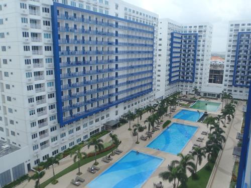 uma vista aérea de um edifício com duas piscinas e palmeiras em Jericho's Place em Manila