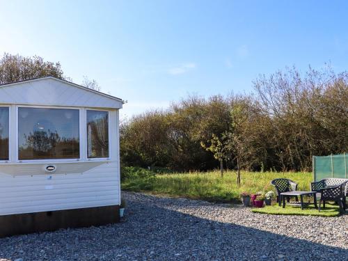 a tiny house with a table and a bench at Hayesland Holiday Home in Tagoat