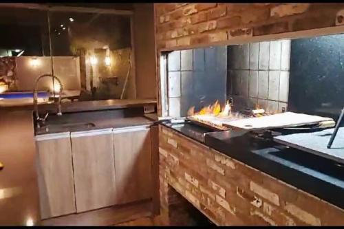 a kitchen with a stove with a fire in it at Praia Xangri-lá Atlântida Capão da Canoa Torres in Xangri-lá