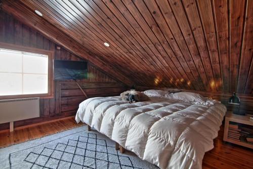 a bedroom with a large bed with a wooden ceiling at Villa Sol Tahko in Tahkovuori