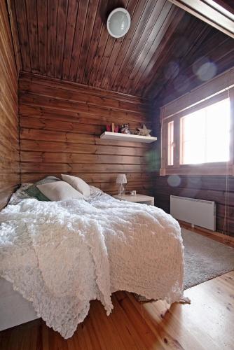 a bedroom with a bed and a wooden wall at Villa Sol Tahko in Tahkovuori