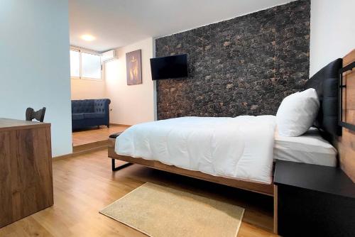a bedroom with a bed and a wall with a tv at Villa Mirasol Hotel in Tangier