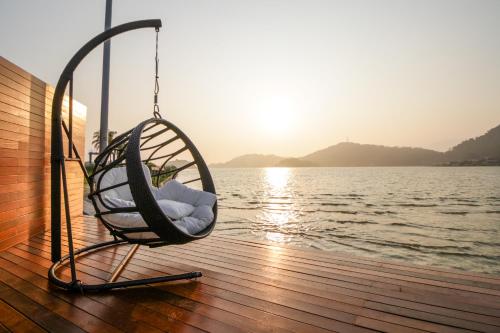 a swinging chair on a boat near the water at VELINN Pousada Angra Sunset in Angra dos Reis