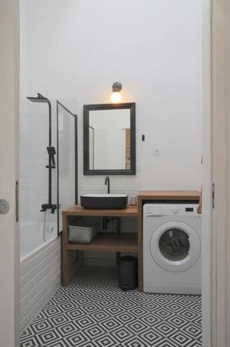 une salle de bain avec un lavabo et une machine à laver dans l'établissement Studio calme aux portes de Paris, à Saint-Denis