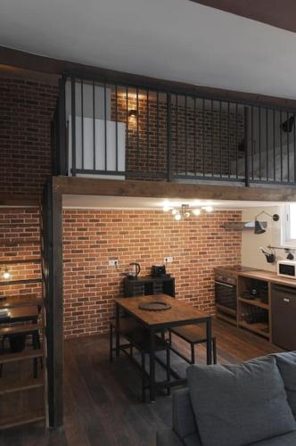 - un salon avec une table et un mur en briques dans l'établissement Studio calme aux portes de Paris, à Saint-Denis