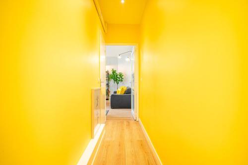 un couloir aux murs jaunes et une chaise dans la chambre dans l'établissement L'Or du Temps / F2 Cosy au coeur de Saint-Ouen, à Saint-Ouen