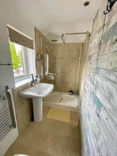 a bathroom with a sink and a bath tub at Little Brook Retreat in Chelmsford