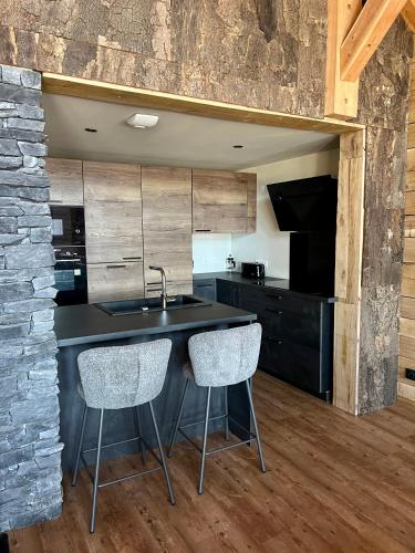- une cuisine avec un évier et 2 chaises dans l'établissement Nouveauté 2024 Chalet Le Lauzaret Villard-Reculas, à Villard-Reculas