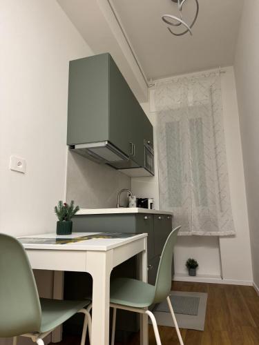 a kitchen with a white table and green chairs at Dreaming Ortona in Ortona