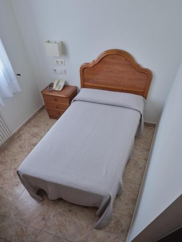 a bedroom with a bed with a wooden headboard at Hotel As Aceas in Narón