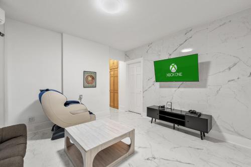 a living room with a chair and a tv on a wall at Epic Spa & Play Retreat NYC EWR Sleeps 30! in Bayonne