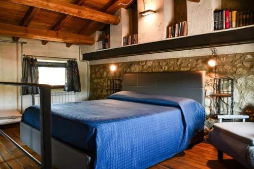 a bedroom with a large blue bed in a room at Rifugio sotto la torre 2 in Olevano Romano