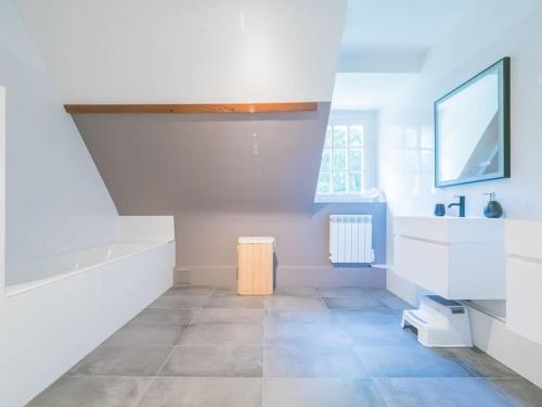 La salle de bains blanche est pourvue d'un lavabo et d'une baignoire. dans l'établissement Maison Cocherel - Collection Idylliq, à Houlbec-Cocherel