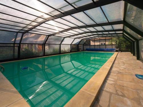 une piscine intérieure avec un toit rétractable dans l'établissement Maison Cocherel - Collection Idylliq, à Houlbec-Cocherel