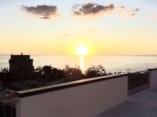 einen Sonnenuntergang über dem Meer vom Balkon eines Hauses in der Unterkunft Open Space The Lighthouse in Paola