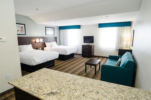 a hotel room with two beds and a couch at MainStay Suites Knoxville Airport in Alcoa