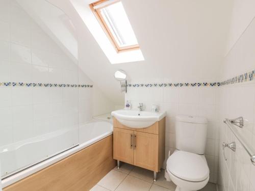 a bathroom with a toilet and a sink and a bath tub at The Beach Hut in Newquay