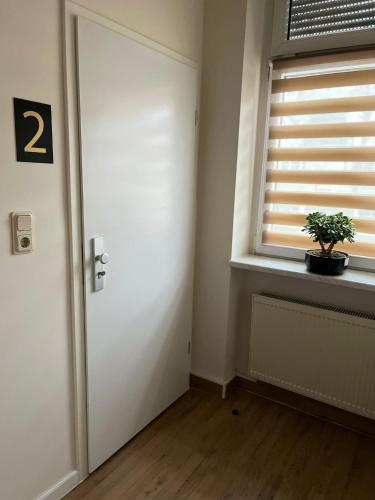 a room with a door and a window with a potted plant at GLOW Apartment in Magdeburg