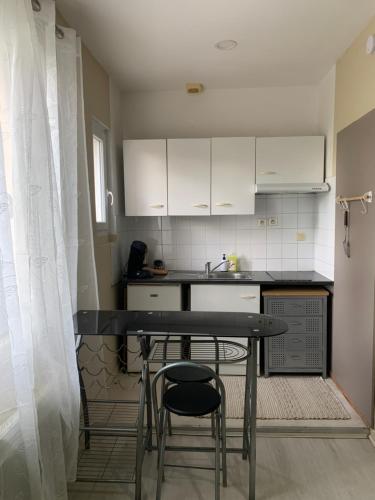 une petite cuisine avec une table et des chaises. dans l'établissement Studio proche auditorium et centre-ville, à Dijon