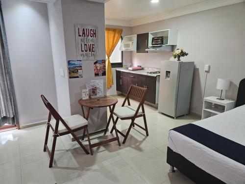 a kitchen with a table and two chairs and a refrigerator at Singular Coyoacán Pepper My Love! in Mexico City