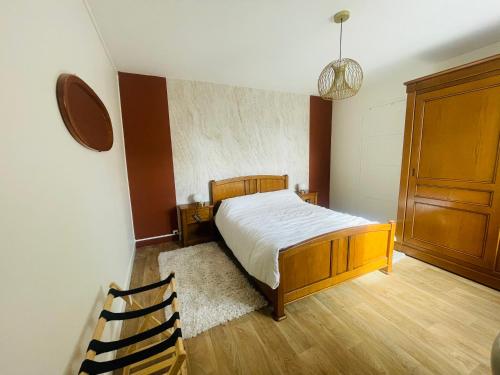a bedroom with a bed and a wooden cabinet at Gite à la campagne 4 étoiles - 200m2 in Sailly