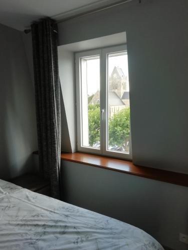 1 dormitorio con ventana y vistas a una casa en Gite Le Jour J, en Sainte-Mère-Église