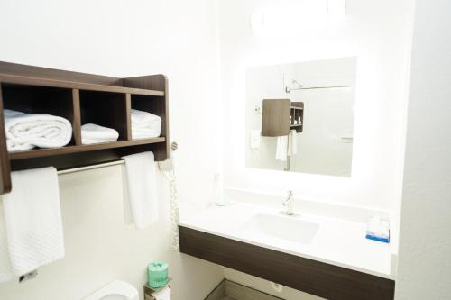 a white bathroom with a sink and a mirror at MainStay Suites Knoxville Airport in Alcoa