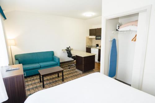 a room with a bed and a couch and a kitchen at MainStay Suites Knoxville Airport in Alcoa