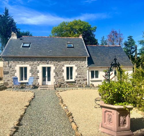a stone house with two blue chairs in front of it at Gite Les Petits Dragons in Carnoët