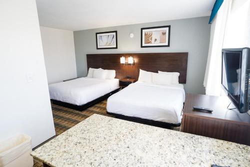 a hotel room with two beds and a flat screen tv at MainStay Suites Knoxville Airport in Alcoa