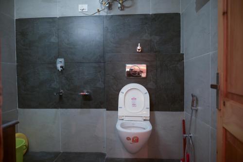 a bathroom with a white toilet in a stall at Zankhrpas A Himalayan Home - Manali in Manāli