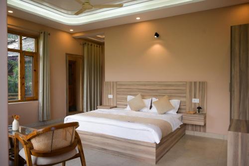 a bedroom with a large bed and a chair at Zankhrpas A Himalayan Home - Manali in Manāli