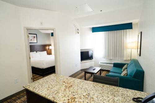 a hotel room with a couch and a bed at MainStay Suites Knoxville Airport in Alcoa