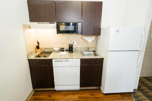 a kitchen with a white refrigerator and a sink at MainStay Suites Knoxville Airport in Alcoa