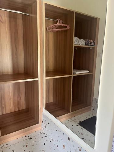 a wooden closet with wooden shelves in a room at Imara - Crafting Memories in Gonikoppal