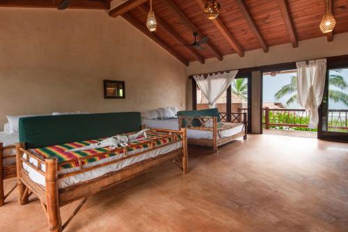 a living room with two beds in a room at Casa Playa Verde - 200Mbps Wifi in Troncones