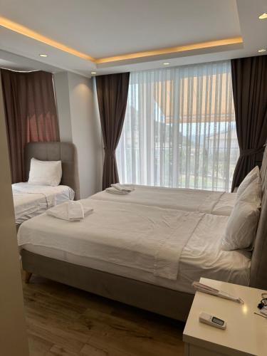 a bedroom with two beds and a large window at Vacation home with private pool, Fethiye, Oludeniz in Cedit