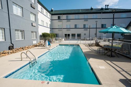 a swimming pool at a hotel with a building at MainStay Suites Knoxville Airport in Alcoa