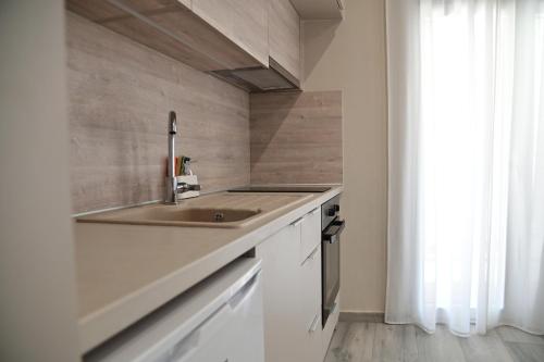 a kitchen with a sink and white cabinets at Valia's Elegance Stays in Alexandroupoli